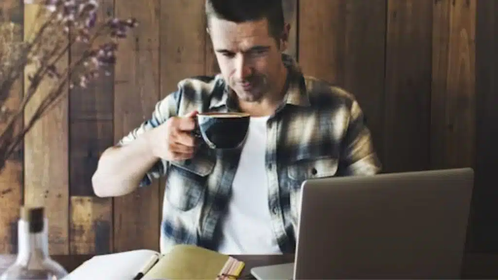 Man reading a book while drinking tea in a cozy café