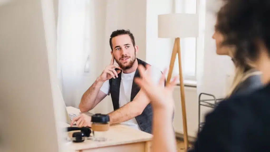 Man smiling while politely refusing with a hand gesture