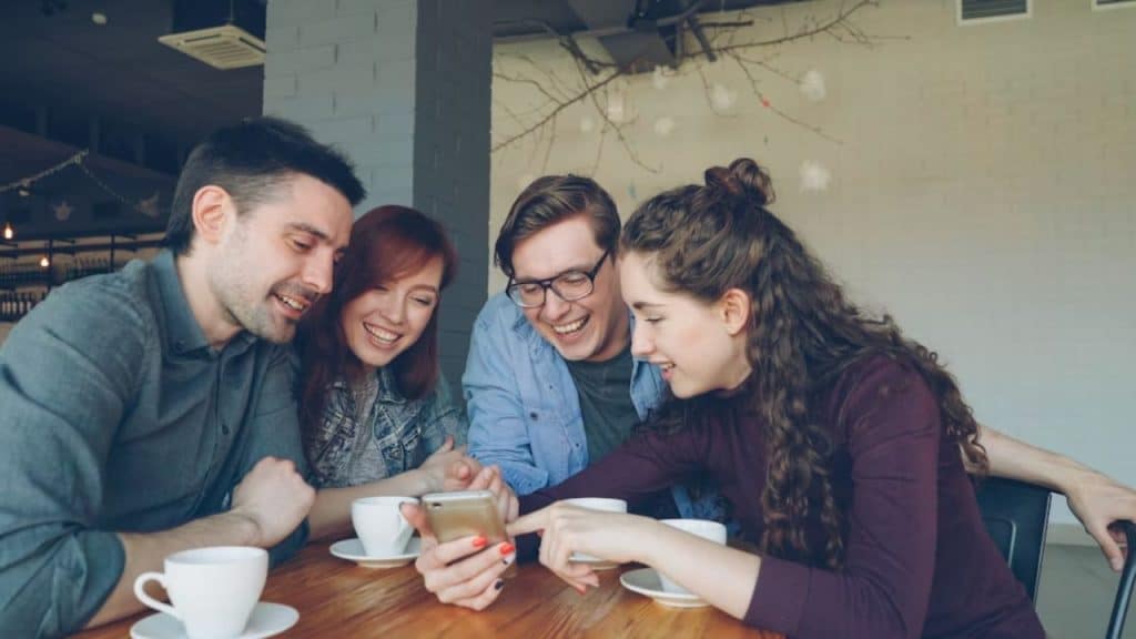 Group of friends laughing together at a café table