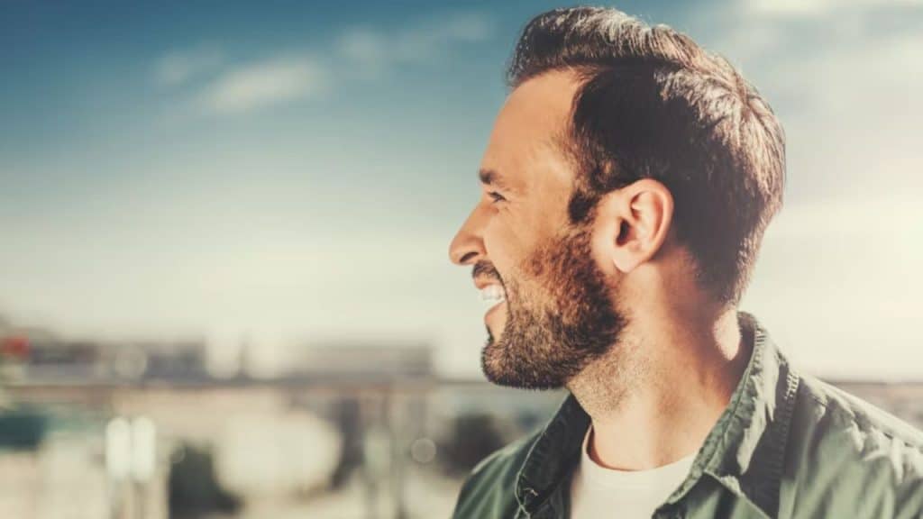 Man smiling outdoors in natural sunlight