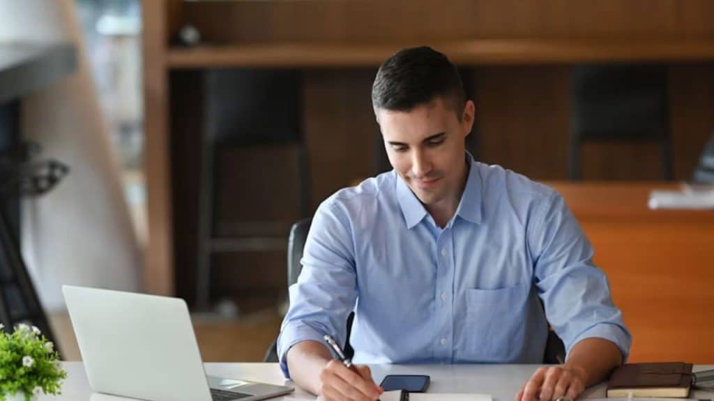 Man writing in a gratitude journal at home