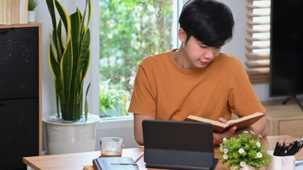 Man reading a book in a quiet corner with coffee