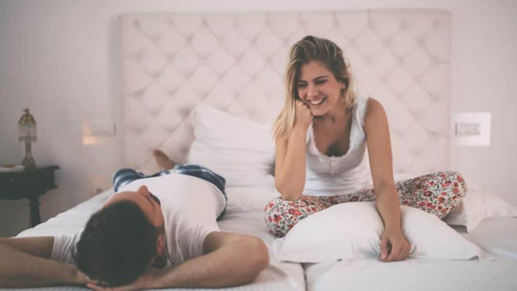 Couple in bed with the man looking withdrawn