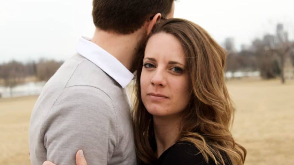 Man holding chest in discomfort but hiding it from his wife