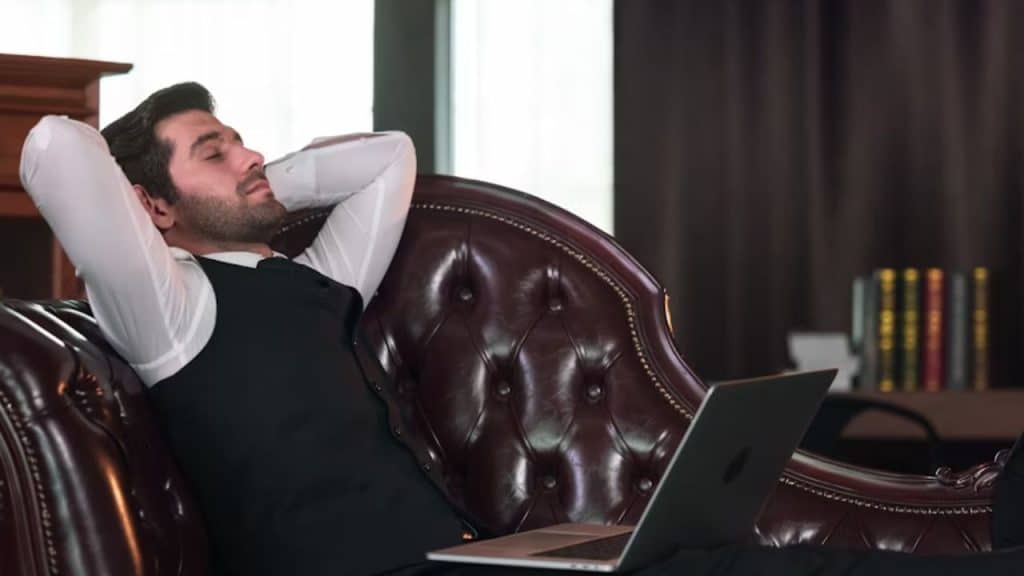 Man exhausted while planning travel itinerary at his desk