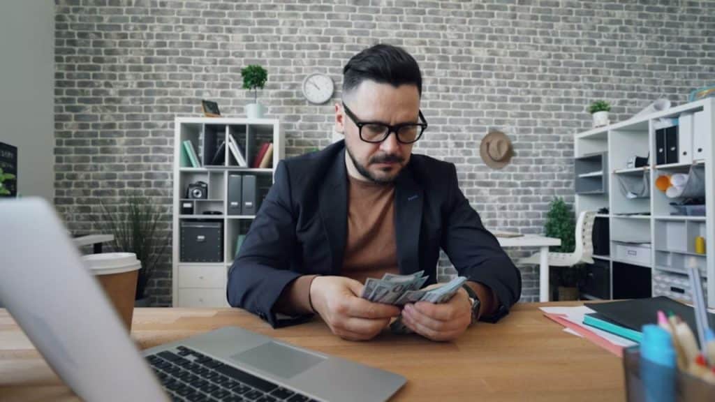 Man holding money with worried expression