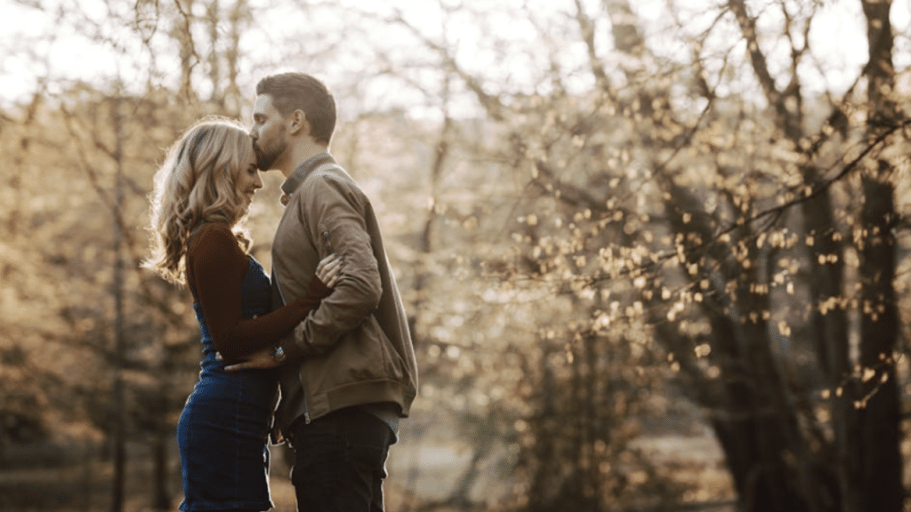 A man kissing his wife’s forehead