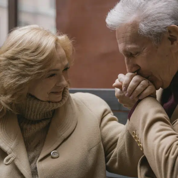 A man kissing his wife’s hand