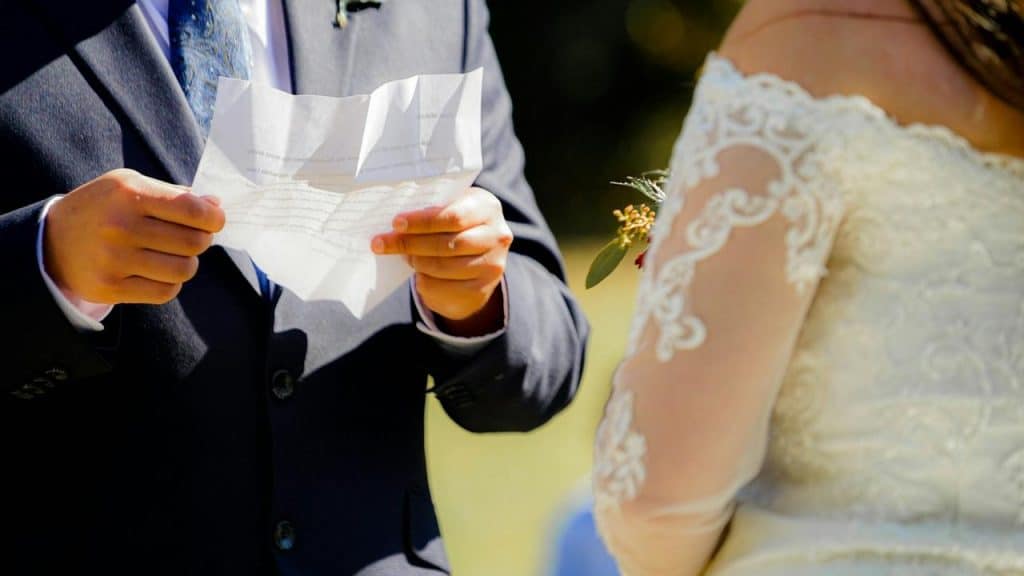 A groom reads vows to his bride during their wedding ceremony.