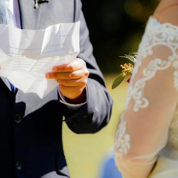 A groom reads vows to his bride during their wedding ceremony.