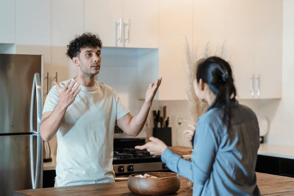A man and woman fighting at the kitchen
