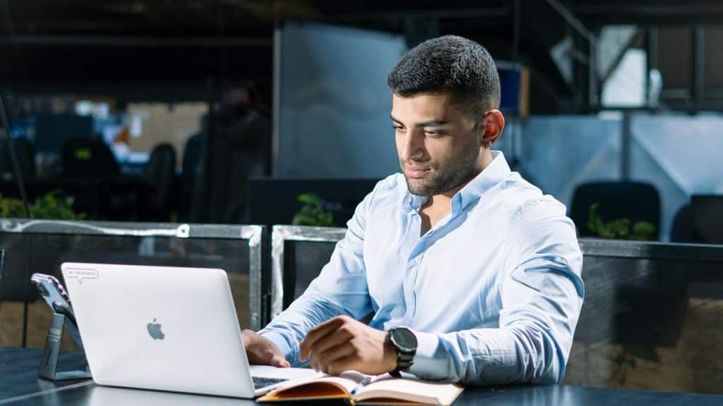 A man working on a laptop at a desk.