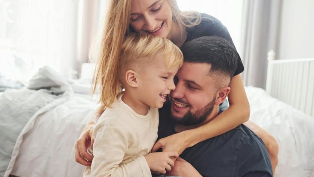 A happy family embracing and smiling together at home.