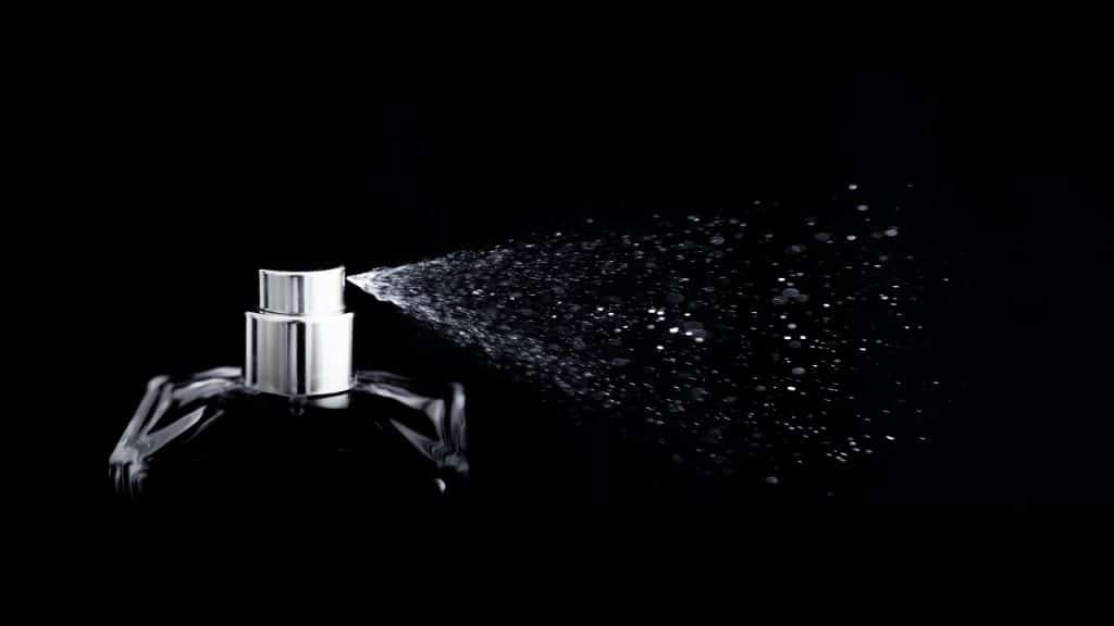 A bottle of perfume being sprayed