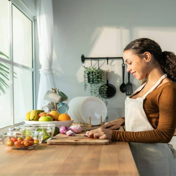 A woman smiling while cooking