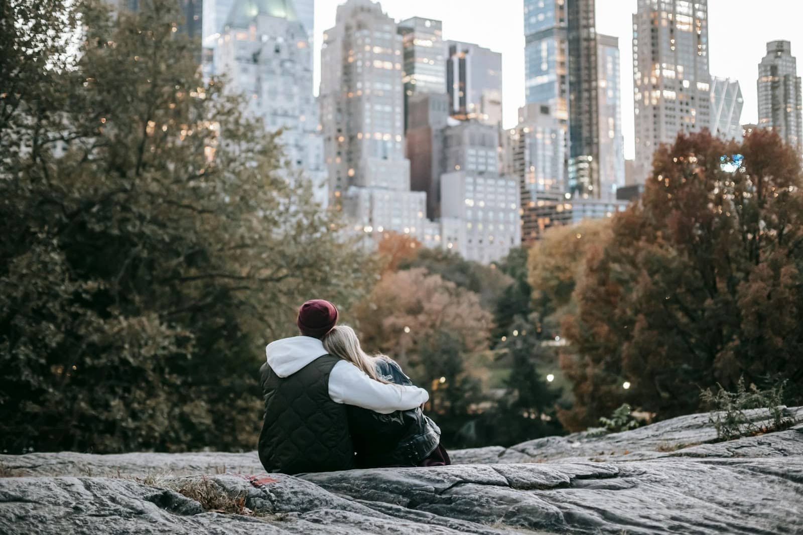 A man and woman sitting and looking at the city view.