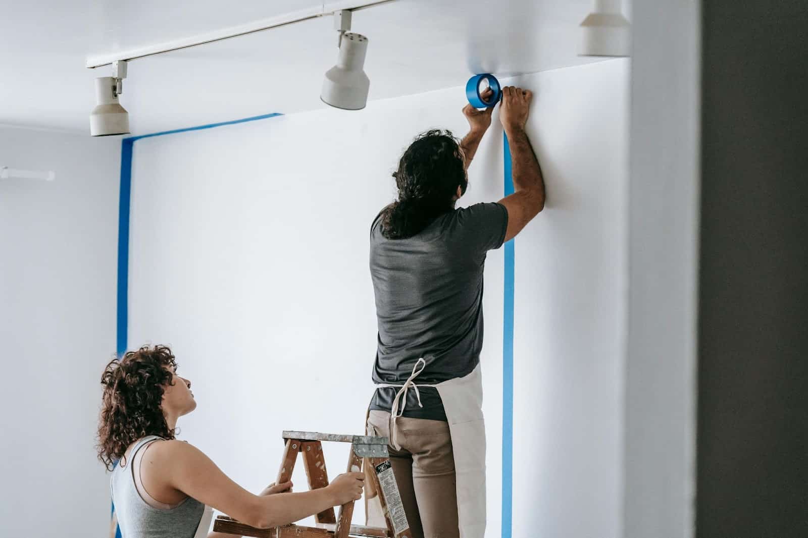 A man and woman renovating their room together.