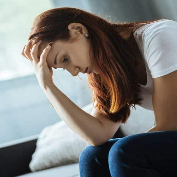 A woman looking sad at home.
