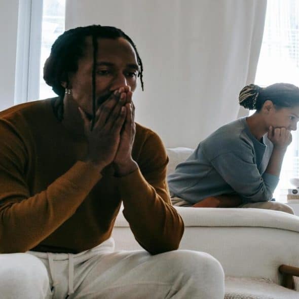 A couple looking sad at home.
