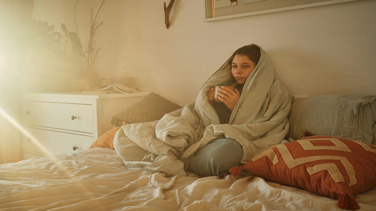 A woman looking sad in the bedroom.