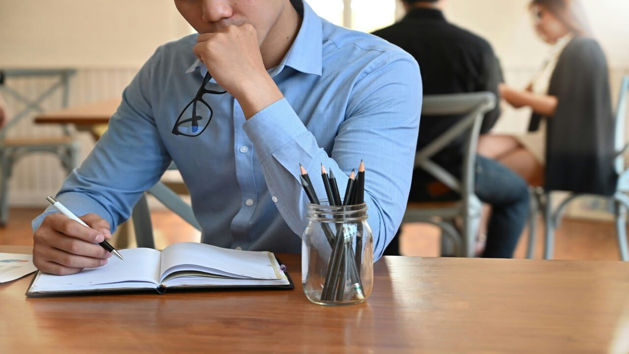 A young businessman writing.