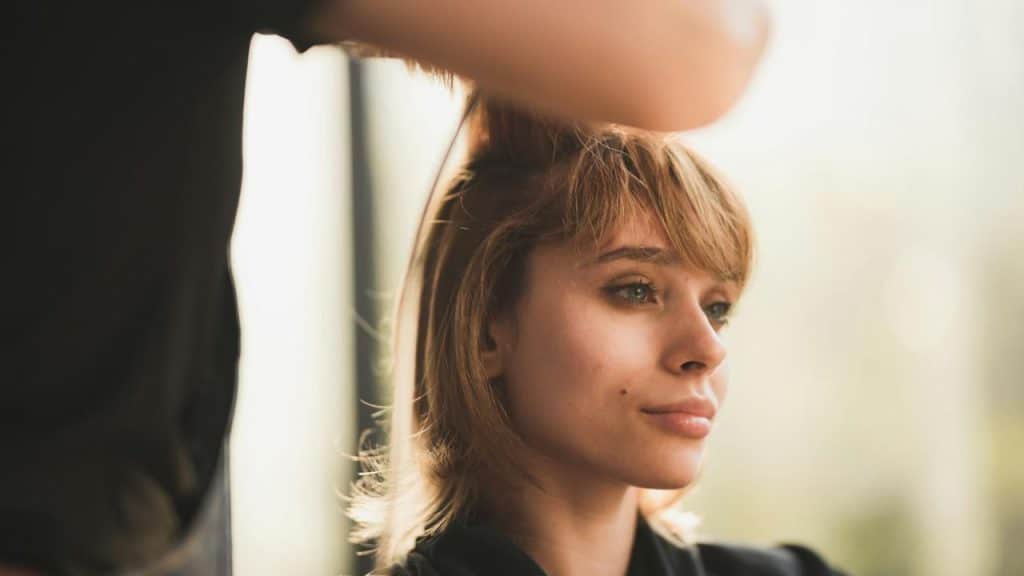 A woman getting her hair styled at a salon.