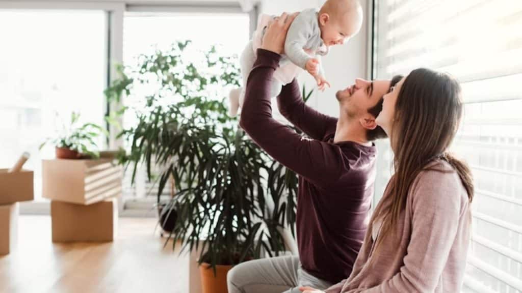 Dad playing with child on the living room floor while mom watches