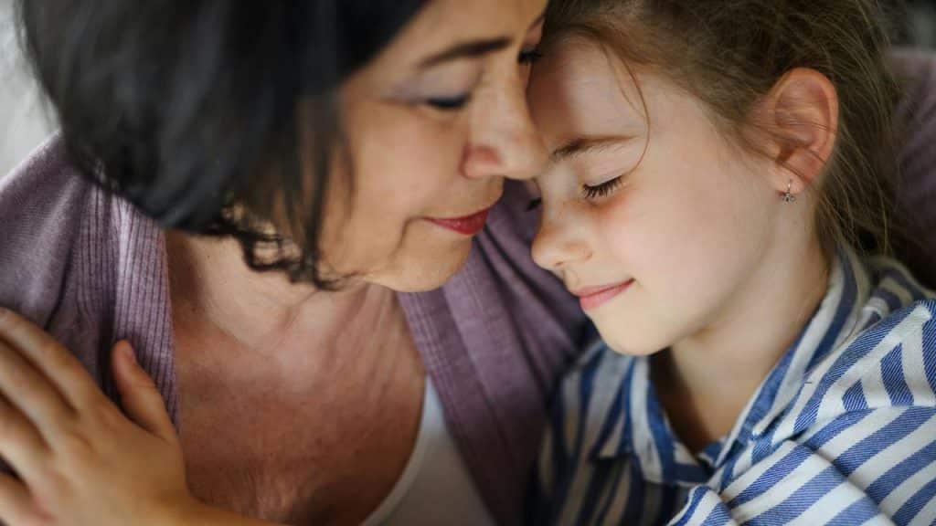 A grandmother and granddaughter sharing a loving embrace.