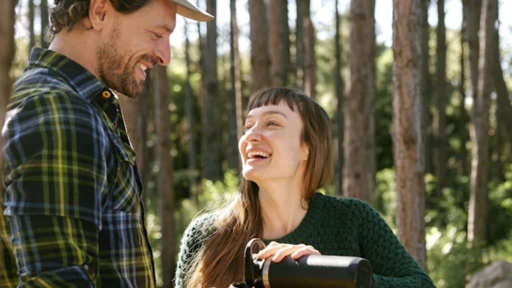 Woman laughing openly while talking with a man outdoors