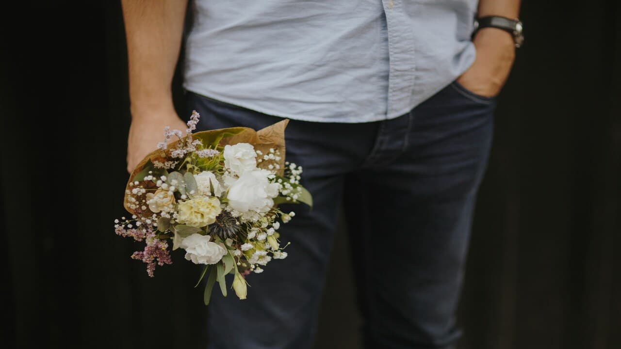 A man holding a bouquet of flowers.
