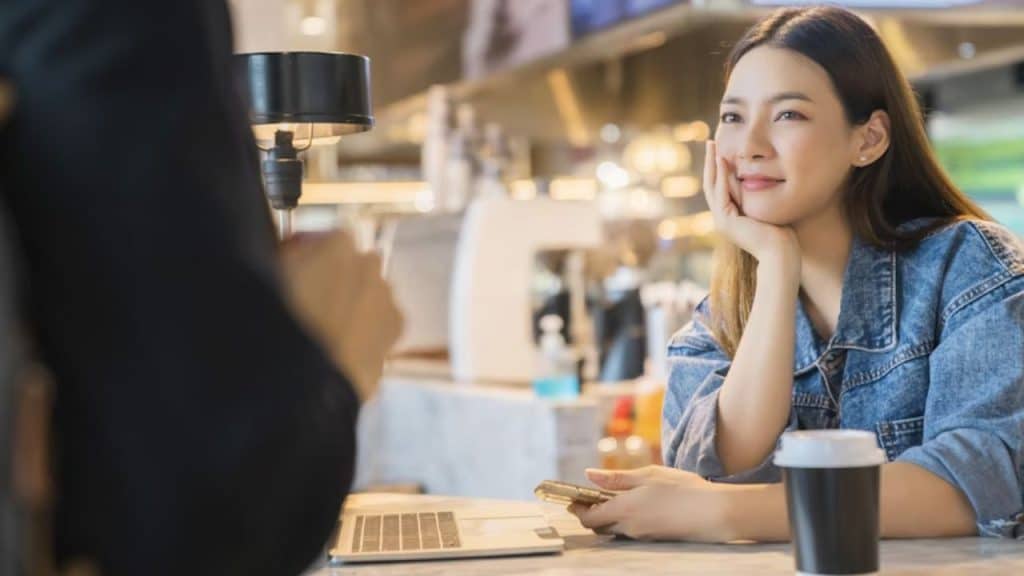 Woman sneaking a look at a man across a restaurant table