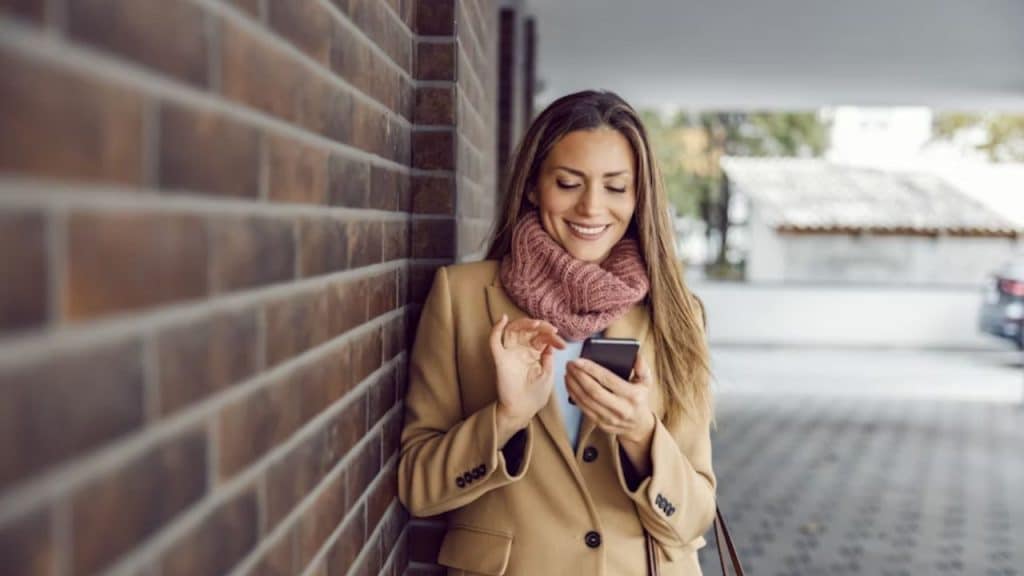 Woman smiling while scrolling on her phone