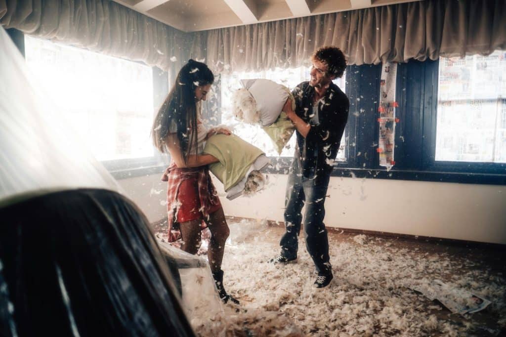 A man and woman pillow fight