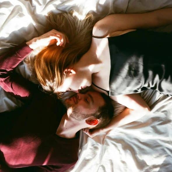 A man and woman laying on bed