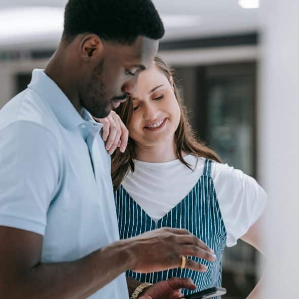 A man and woman looking at the phone