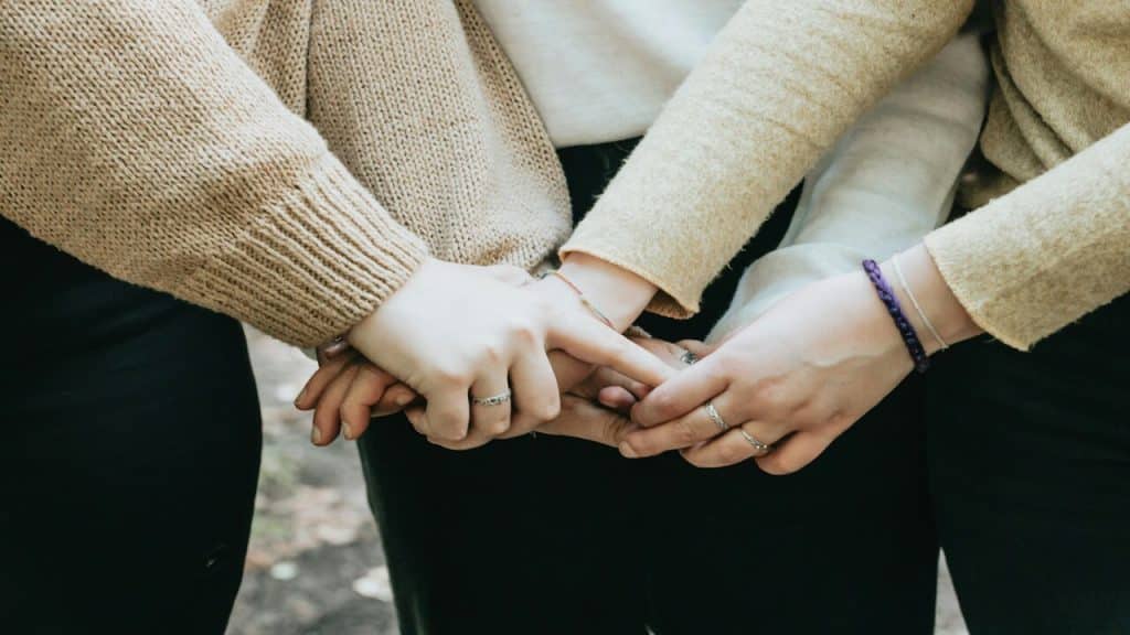 Three people holding hands