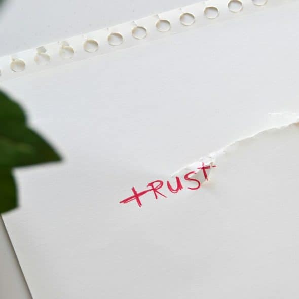 The word “trust” written on torn paper