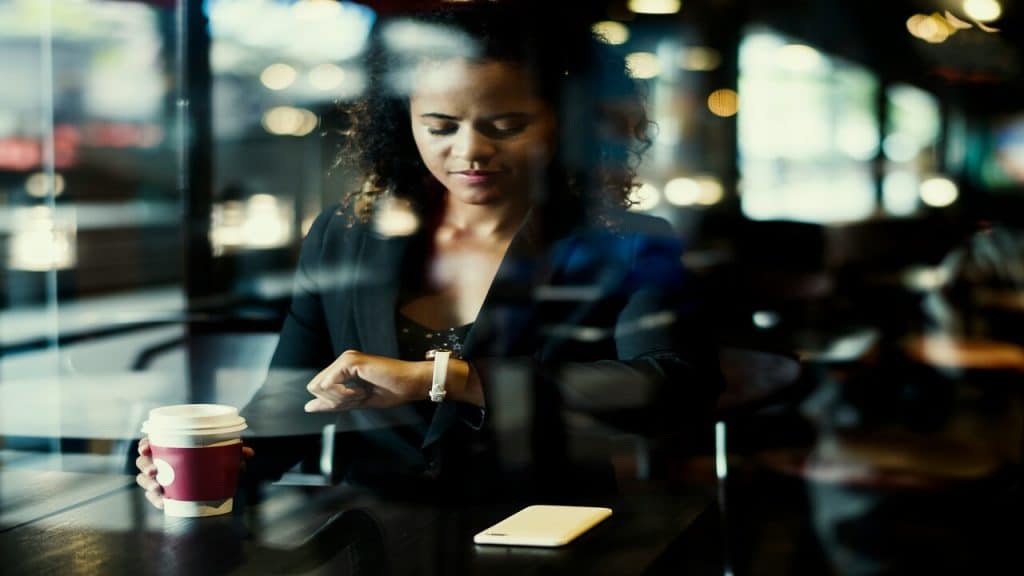 A woman looking at her wristwatch while waiting