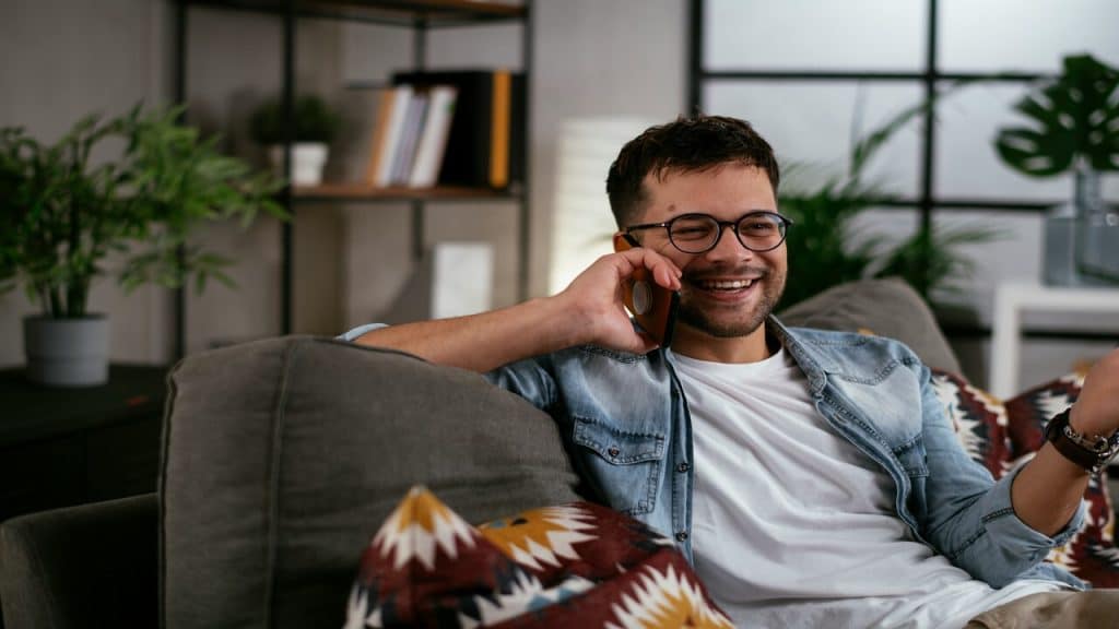 A man smiling while on the phone