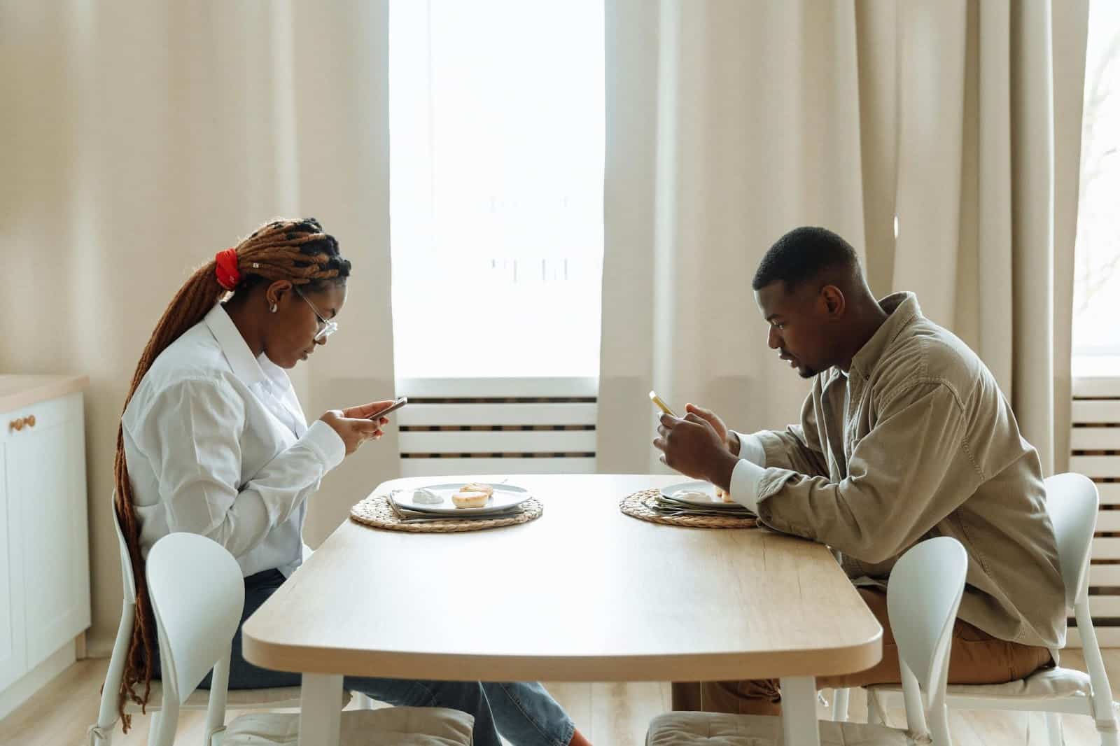 A man and woman not talking while eating.