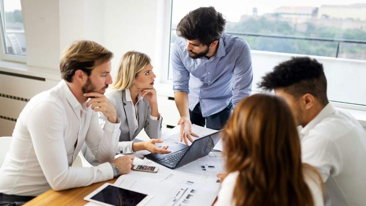 A young, diverse business team is meeting in an office to discuss a project.