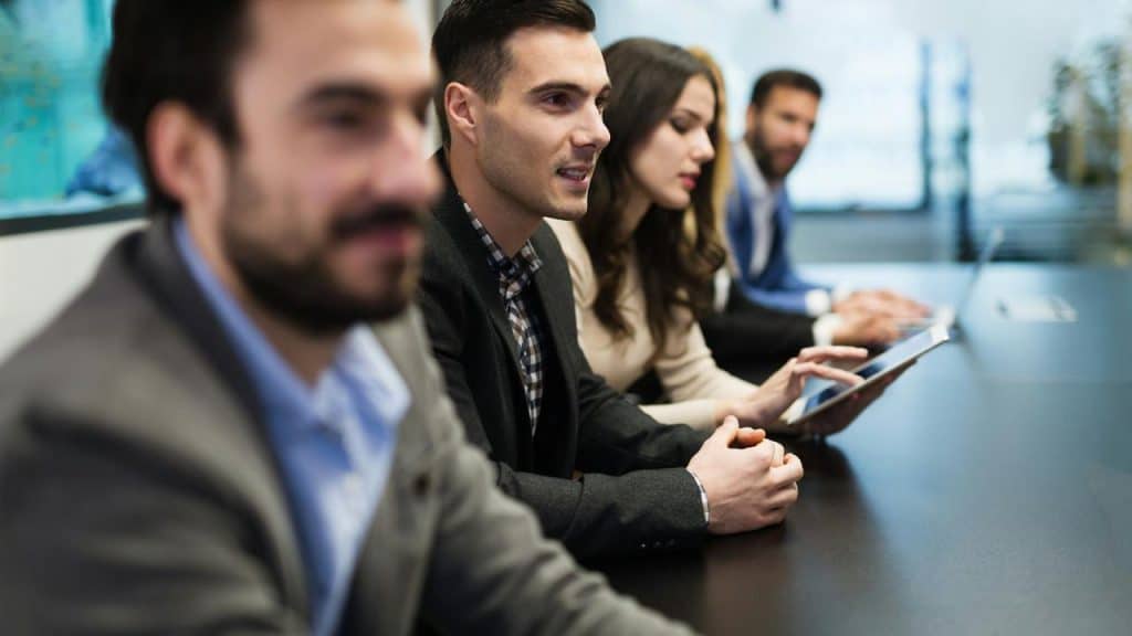 A group of people sitting at a conference table during a meeting.