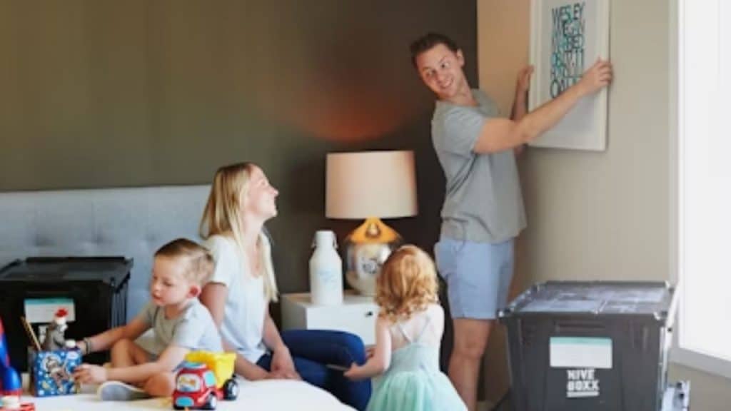 Husband hanging the wall decor and helps in cleaning  the house