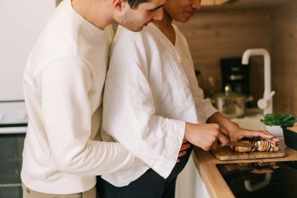 A man helping a pregnant woman at the kitchen