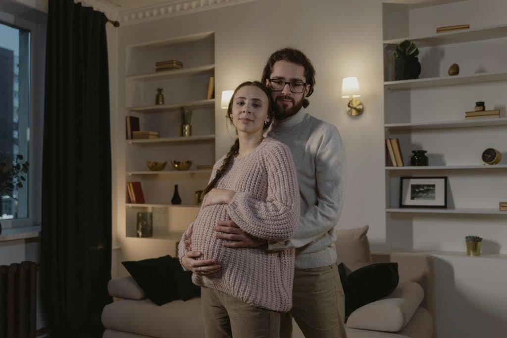 A man embracing a pregnant woman