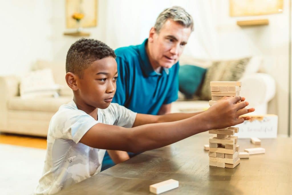 A father playing jenga with his son