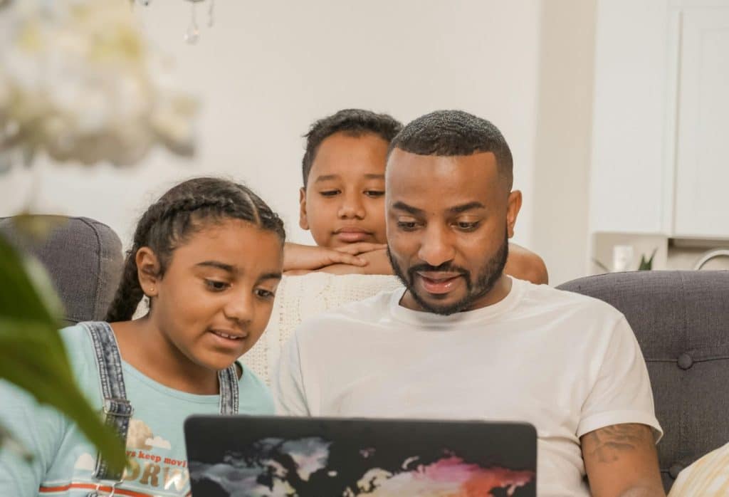 A man working and his son and daughter watching him