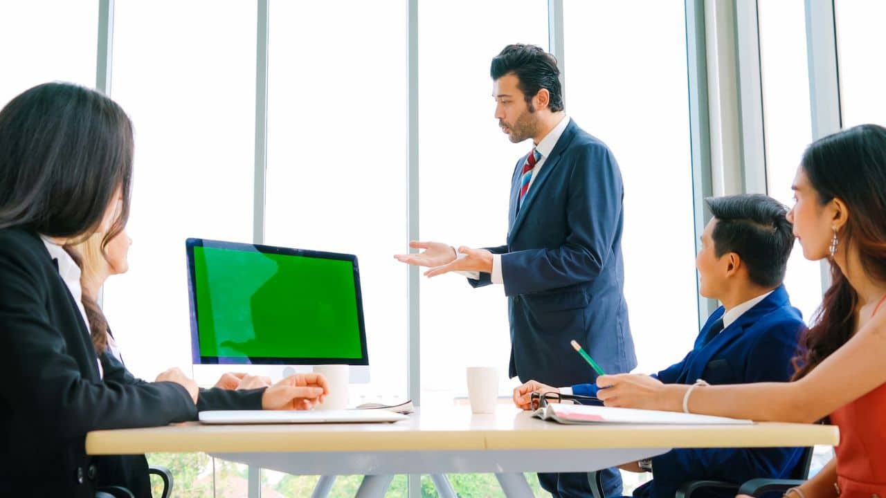 A business team is in a meeting room with a large window.