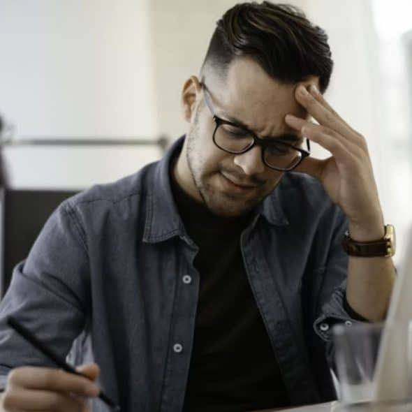 Man sitting alone in a room reflecting about his relationship and feeling frustrated.