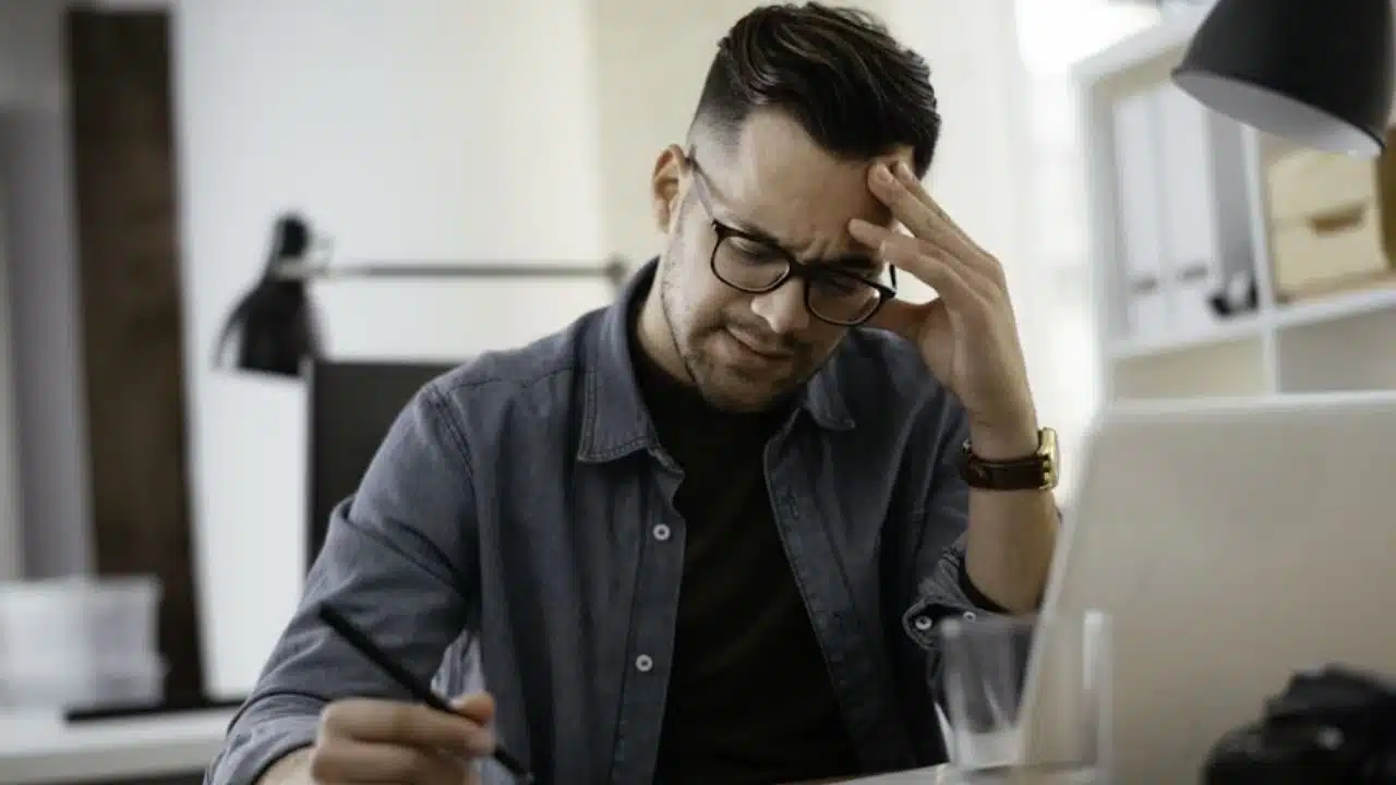 Man sitting alone in a room reflecting about his relationship and feeling frustrated.